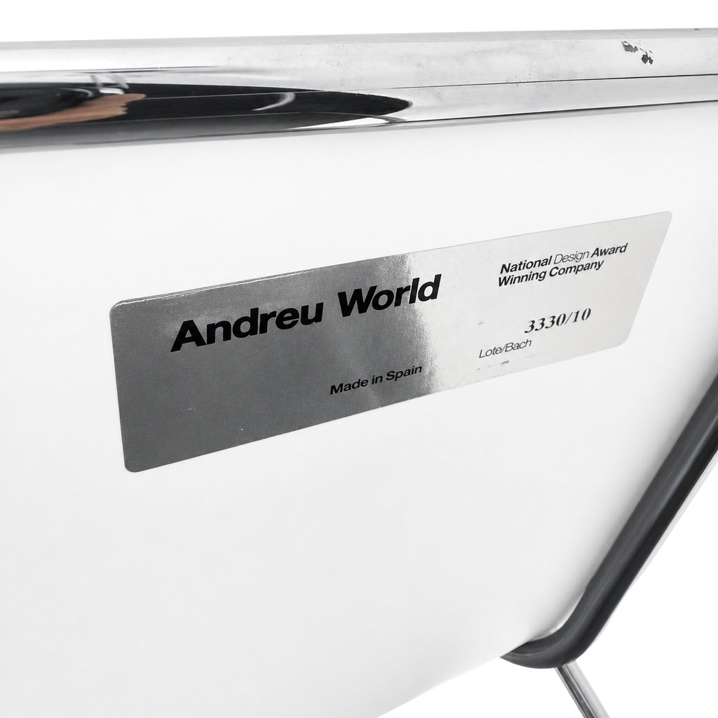 Andreu World Lineal Barhocker mit weißer Sitzschale, verchromtem Metallgestell und Hersteller-Label auf der Rückseite.