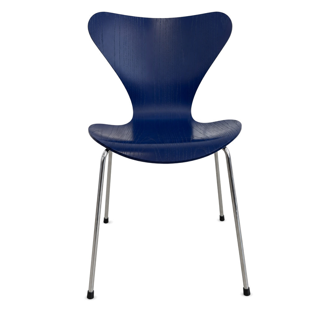 Blauer Fritz Hansen Serie 7 Stapelstuhl aus Holz mit verchromtem Untergestell vor weißem Hintergrund.