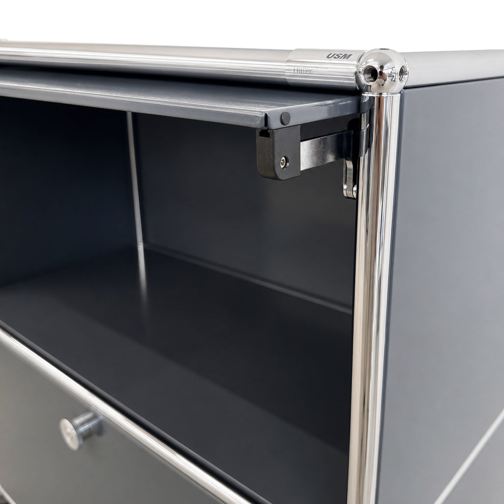 Anthrazitfarbenes USM Haller Sideboard mit Einschubtür, Chromrohr-Rahmen und hochwertigen Metallverbindungen.