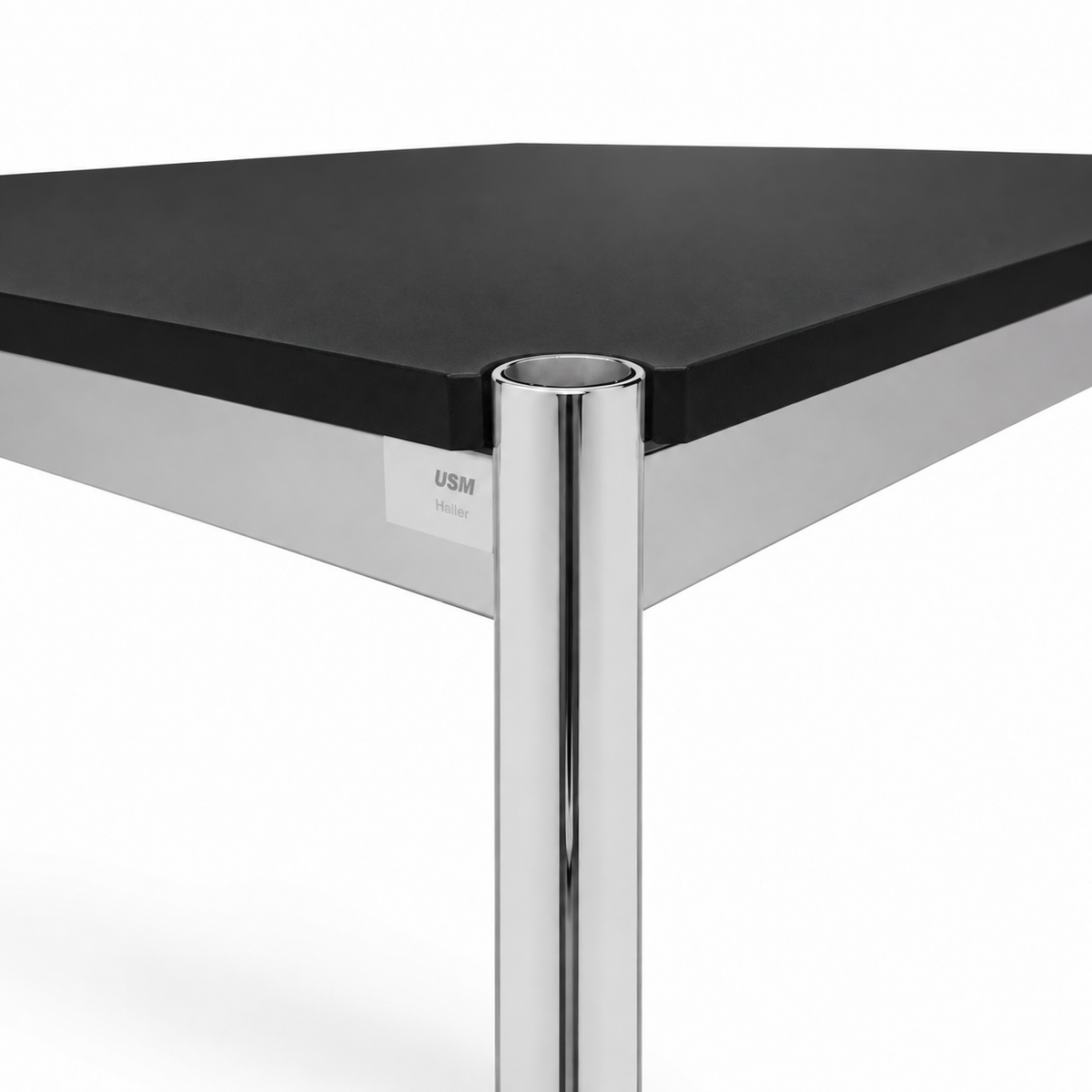 USM Haller Tisch mit schwarzer Fenix-Tischplatte und verchromtem Stahlgestell im Detail.