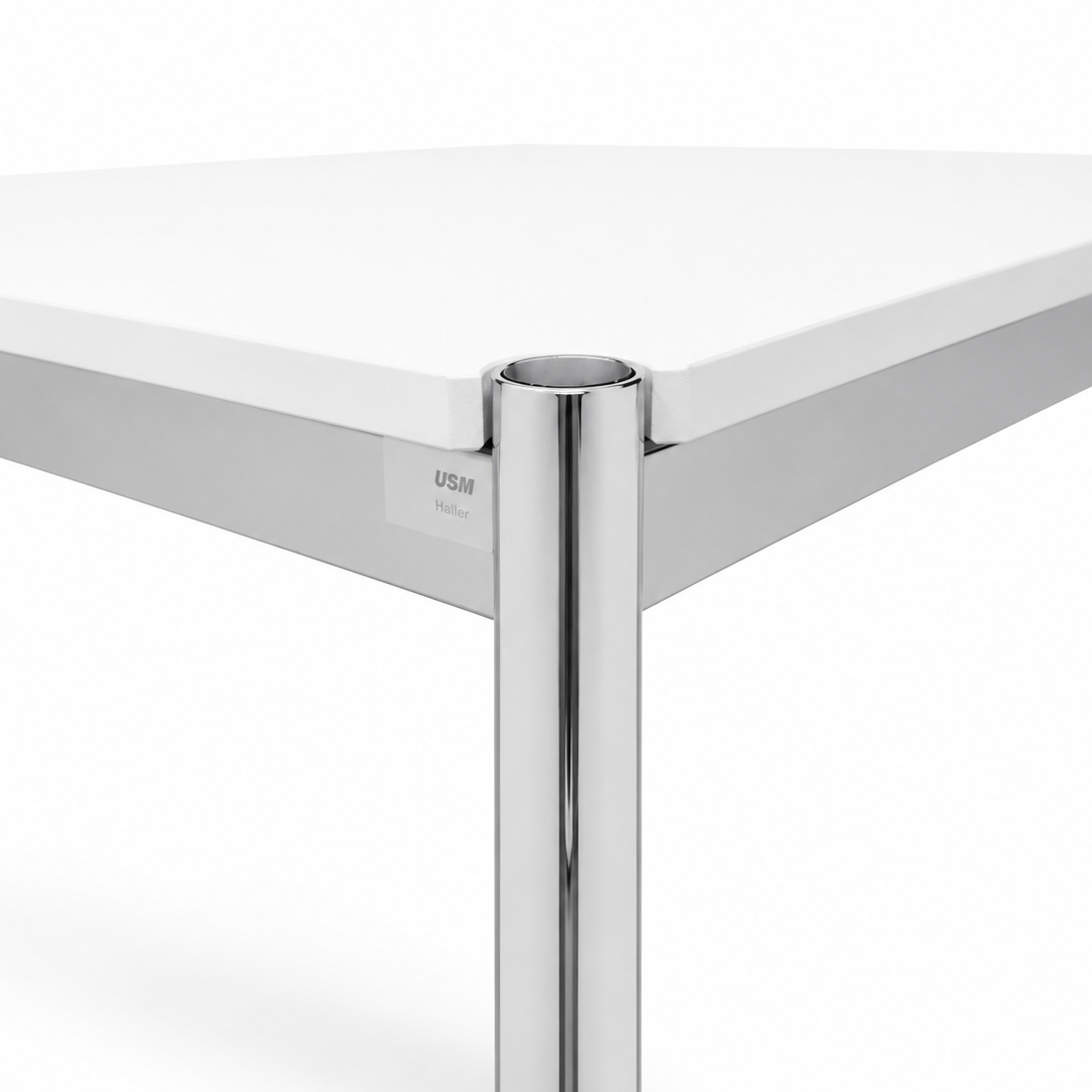 USM Haller Tisch mit reinweißer MDF-Platte und verchromtem Stahlgestell im Detail.