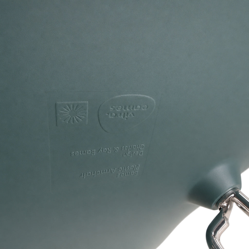 Petrolblaue Vitra Eames Plastic Armchair Sitzschale mit eingeprägtem Logo und glänzendem Chrom-Gestell.