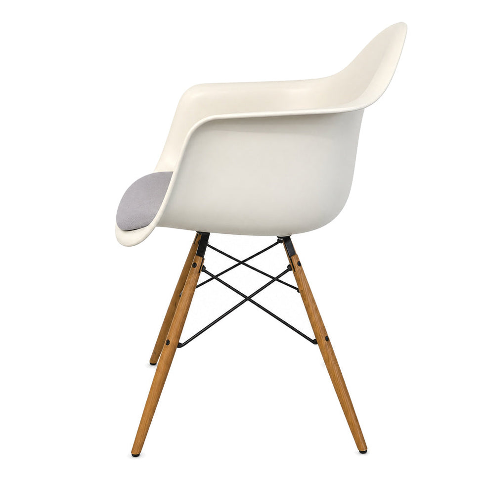 Vitra Eames DAW Armlehnstuhl mit weißer Sitzschale, hellgrauem Polster und Ahornholz-Gestell auf weißem Hintergrund.