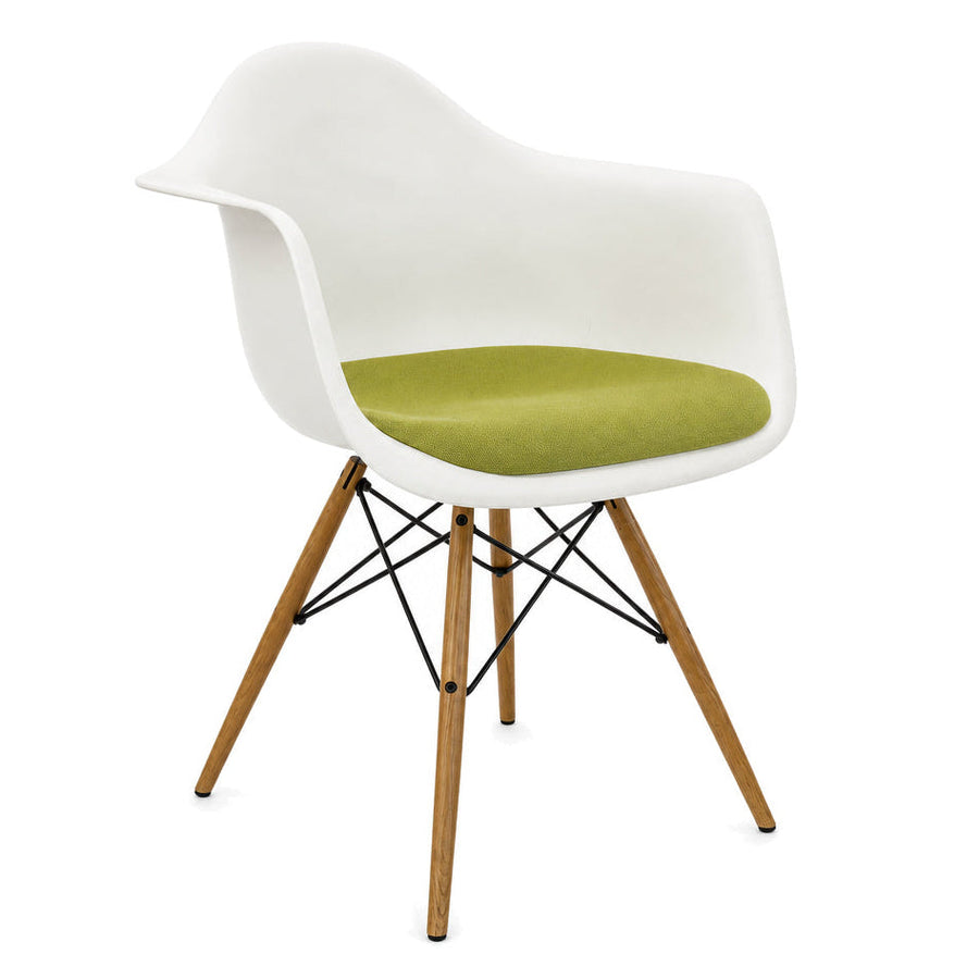 Vitra Eames DAW Armlehnstuhl mit weißer Sitzschale, grünem Polster und Ahornholz-Gestell mit schwarzen Metallverstrebungen.