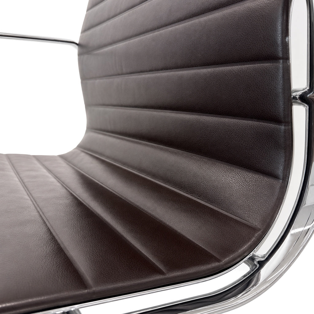 Vitra Eames Alu Chair EA108 mit dunkelbraunem Lederbezug und glänzendem Chromgestell in Nahaufnahme.