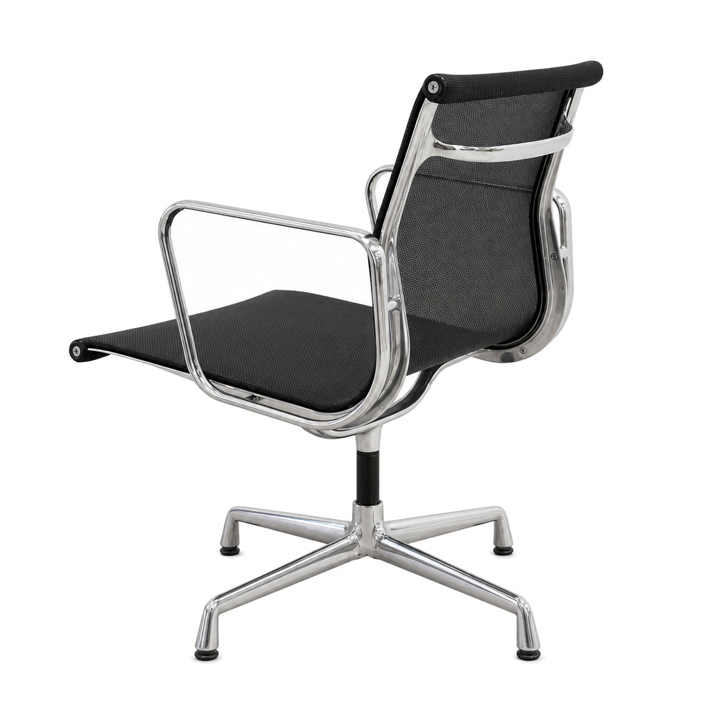 Vitra Eames Alu Chair EA 108 mit schwarzem Netzbezug und poliertem Aluminiumgestell auf weißem Hintergrund.