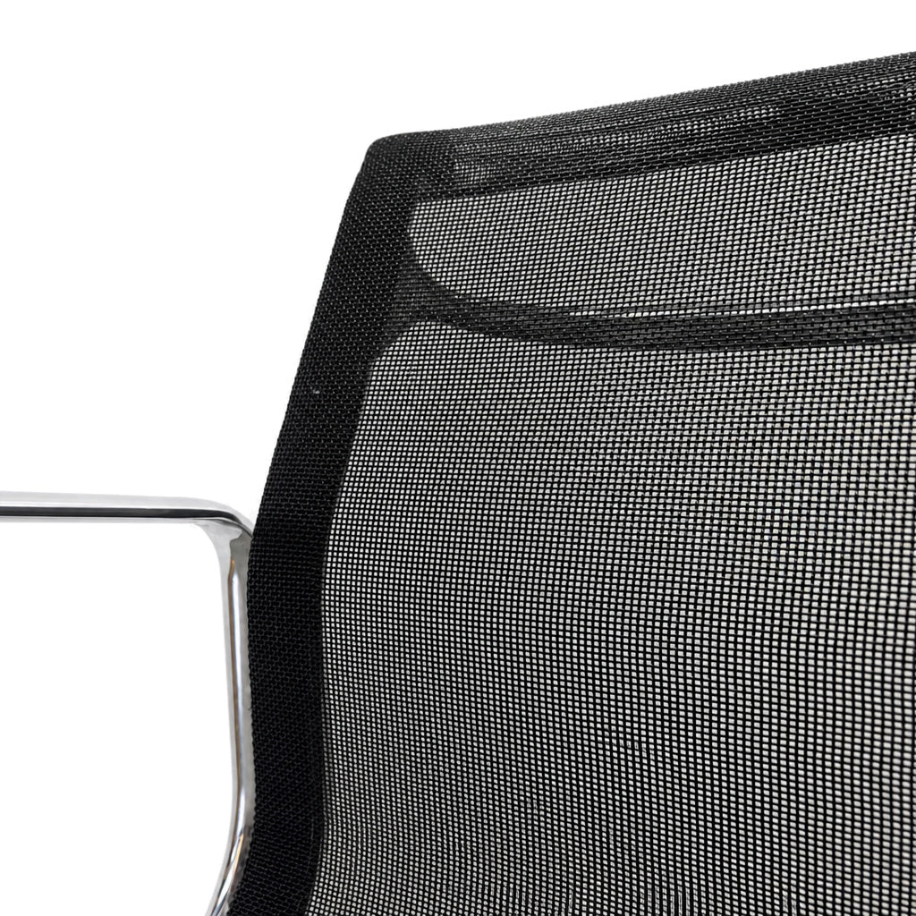 Detailaufnahme der schwarzen Netzbespannung und des polierten Aluminiumrahmens des Vitra EA 108 Eames Alu Chair.